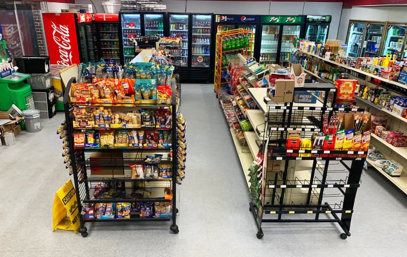 Fully stocked convenience store interior with coolers and aisles